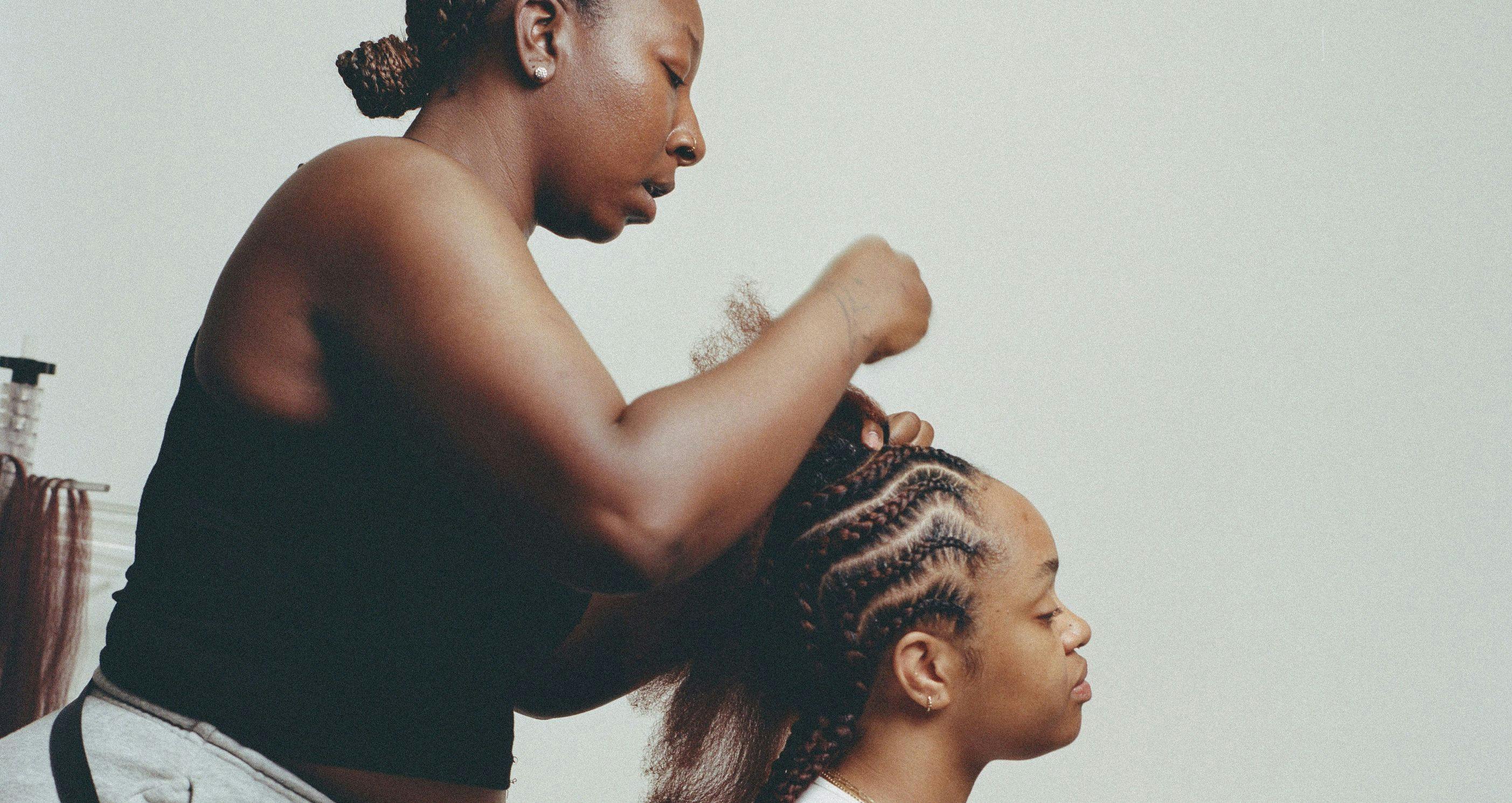 woman braiding a client's hair